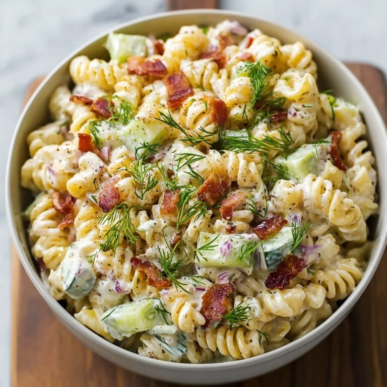 Dill pickle bacon pasta salad in a large bowl with fresh dill