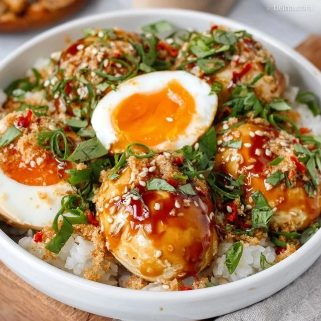 Close-up of marinated soy egg cut in half showing perfect jammy orange yolk, bouncy egg white with soy-stained tan exterior, glossy marinade dripping, sesame seeds clinging